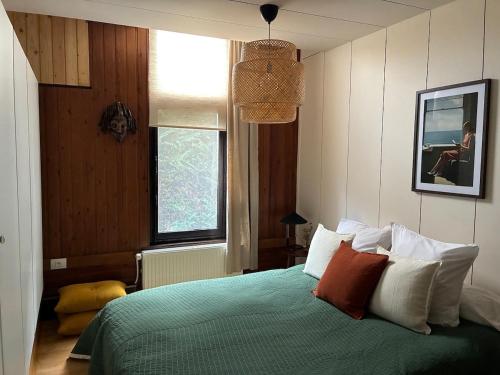a bedroom with a green bed and a window at Cozy house in Olmen in Balen