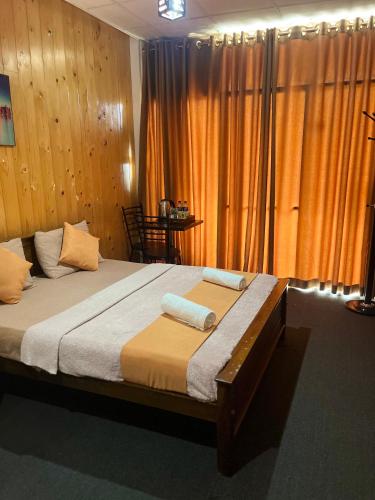 a bedroom with a bed with two towels on it at The Natures Nuwaraeliya in Nuwara Eliya
