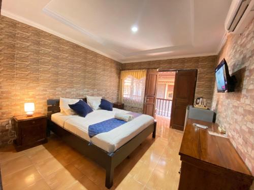 ein Schlafzimmer mit einem Bett und einem Flachbildfernseher in der Unterkunft ABI Hotel4 - 1 minute to the Beach and 1 second to the Mall in Ngurah Rai International Airport