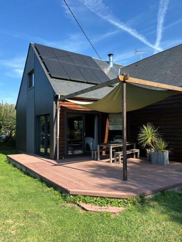 a wooden deck with a tent on a house at Grande maison en bois eco-responsable proche de la mer in Saint-Germain-sur-Ay