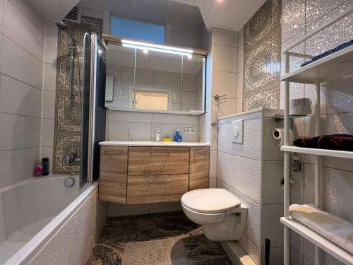 a bathroom with a toilet and a tub and a sink at LuxusCityApartment in Berlin