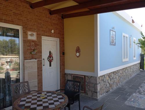a porch of a house with a table and chairs at Athinas Art House in Kolymbia