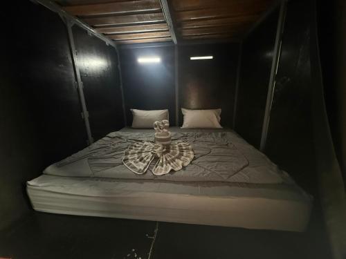 a small bed in a black room with at Alura Hostel in Kata Beach