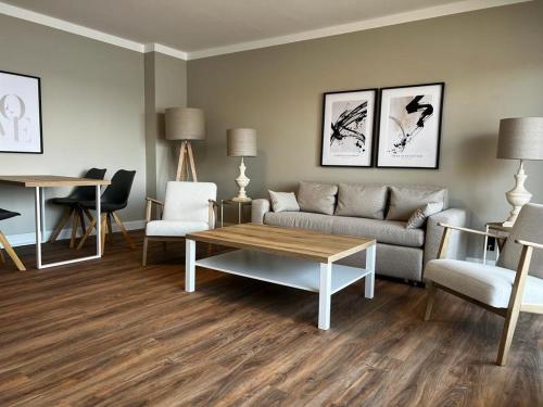 a living room with a couch and a table and chairs at Landhuus Dieksee in Malente