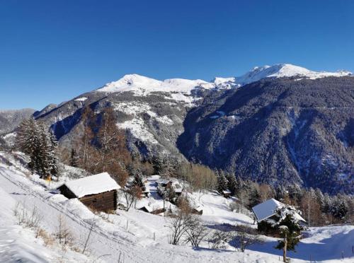 a snow covered mountain with a house in the foreground at Hüttli Chalet mit atemberaubendem Weitblick in Naters