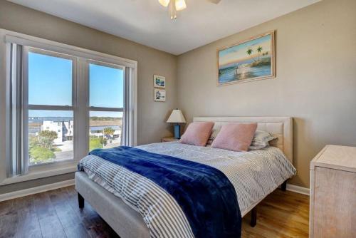 Chadwick AcresTopsail Dunes的一间卧室，里面有一张床和一扇大窗户。