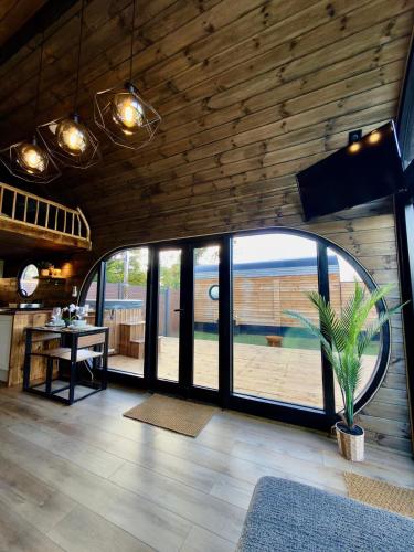 a living room with a table and a large window at Luxury Tiny Home next to Belfry Golf Course Highland Cow
