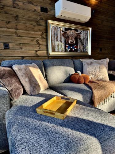 a living room with a blue couch with a picture of a tiger at Luxury Tiny Home next to Belfry Golf Course Highland Cow