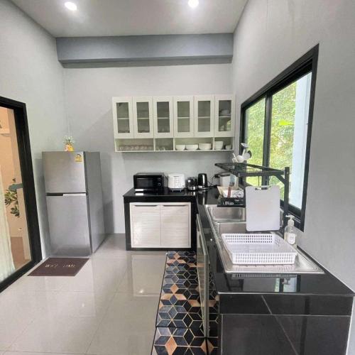 a kitchen with a counter and a refrigerator at Natnicha Pool Villa Hatyai in Ban Nam Noi