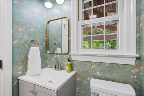 a bathroom with a toilet and a sink and a mirror at The Raleigh Resort House in Millbrook