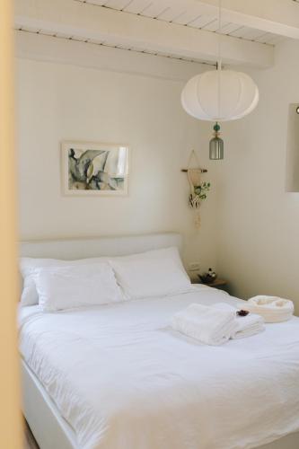 a bedroom with a white bed with a white blanket at Matar baYaar מטר ביער in El-Rom