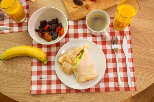 a plate of food with a sandwich and a bowl of fruit at The Gate by Zoia Living in Athens