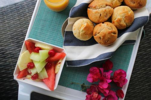 a plate of food with fruit and muffins and a drink at French Leave Resort, Autograph Collection in Governorʼs Harbour