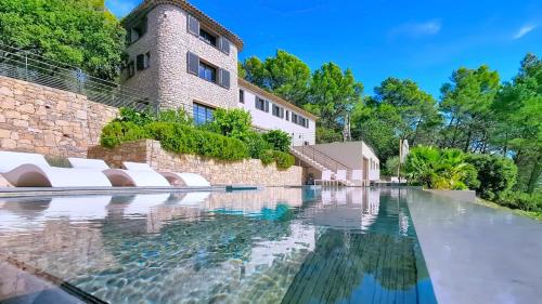 a swimming pool in front of a building at Villa de Prestige au Calme avec Vue exceptionnelle in Lorgues