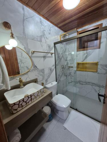 une salle de bain avec un lavabo, une douche et des toilettes dans l'établissement Anexxo HC, à Palhoça