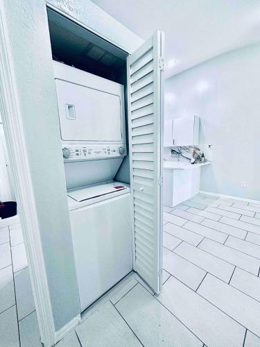 a small white kitchen with a refrigerator in a room at Cape Coral Seascape in Cape Coral