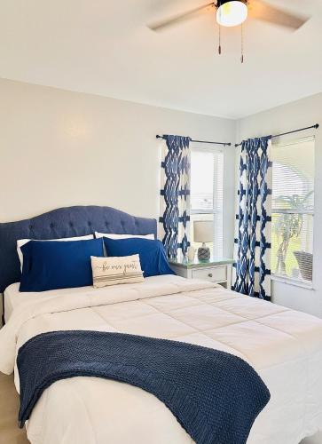 a bedroom with a large bed with blue pillows at Cape Coral Seascape in Cape Coral