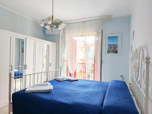 a bedroom with a blue bed and a window at Alba sul Mare Apartments in Ali Terme