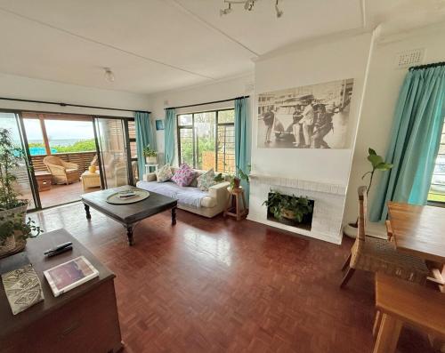 a living room with a couch and a fireplace at Wazos Beach Villa in Durban