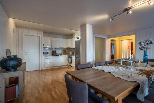 a kitchen and dining room with a wooden table and chairs at Large Ski in-Ski out Apartment for Groups in Hemsedal