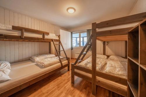 two bunk beds in a room with wooden floors at Large Ski in-Ski out Apartment for Groups in Hemsedal
