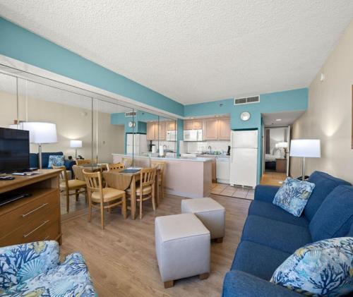 a living room with a blue couch and a kitchen at Barclay Towers by CoolVacay in Virginia Beach