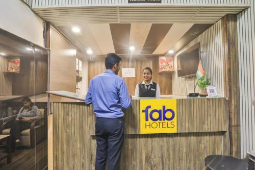 un hombre hablando con una mujer en recepción en FabHotel LS Grand, en Varanasi