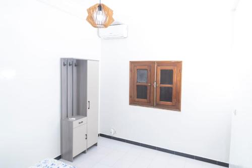 a white room with a door and a window at Appartement Meublée Confort et Élégance au Mariste in Dakar