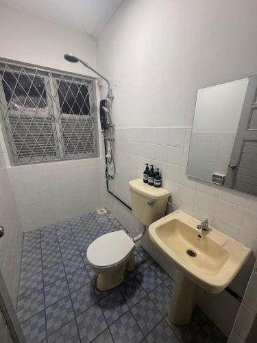 a bathroom with a toilet and a sink at Authentic Local Terrace House in Kuching in Kuching