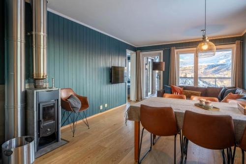ein Wohnzimmer mit Tisch und Kamin in der Unterkunft Family-Friendly Ski in-Ski out Retreat by Skarsnuten in Hemsedal