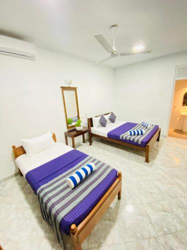 two beds in a room with purple and white at Cozy Space - Madiha in Matara