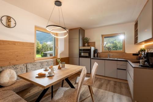 a kitchen and dining room with a wooden table at Apart Garber in Zellbergeben