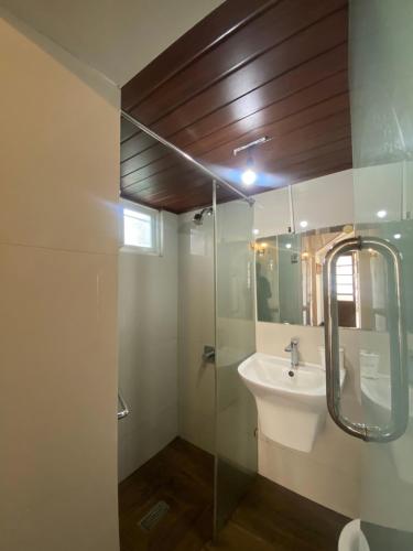 ein Badezimmer mit Waschbecken und Glasdusche in der Unterkunft Peak View Cottage in Nuwara Eliya