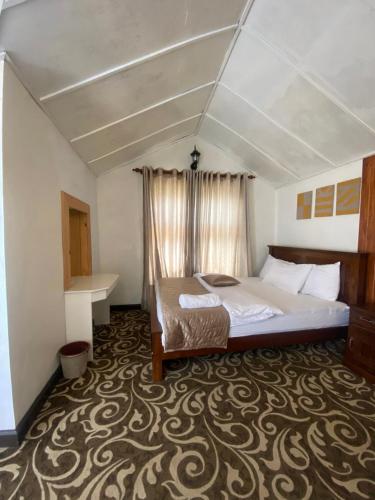 ein Schlafzimmer mit einem Bett und einem Teppich in der Unterkunft Peak View Cottage in Nuwara Eliya