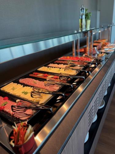 Una línea de buffet con muchos tipos diferentes de comida. en Balaton Park Hotel, en Balatonfőkajár