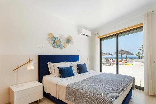 a bedroom with a bed with a view of the beach at On The BEACH Stunning Apartment Albufeira Olhos de Água in Albufeira