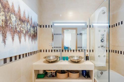 a bathroom with two bowls on a counter in front of a shower at On The BEACH Stunning Apartment Albufeira Olhos de Água in Albufeira