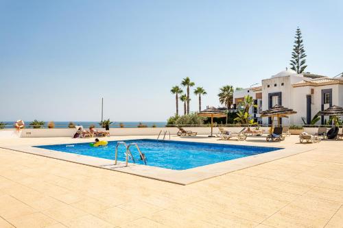 a swimming pool in front of a resort at On The BEACH Stunning Apartment Albufeira Olhos de Água in Albufeira