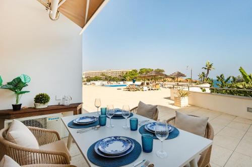 a dining table with a view of the beach at On The BEACH Stunning Apartment Albufeira Olhos de Água in Albufeira