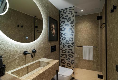 a bathroom with a sink and a toilet and a mirror at NYX Hotel Thessaloniki in Thessaloniki