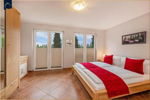 a bedroom with a large bed with red pillows at Tema 4 in Ahlbeck