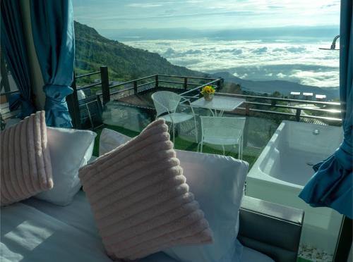a balcony with pillows and a view of the mountains at น่านฟ้าธาราหมอก ภูทับเบิก in Ban Tha Kok Hai