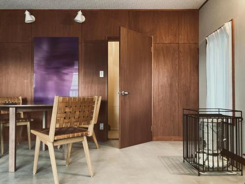 une salle à manger avec une table et une chaise dans l'établissement 森と温もりに包まれる長野飯綱高原の隠れ宿ヴァイオレットハウス, à Nagano