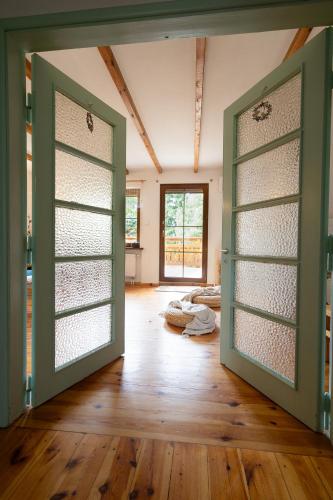 an open door in a room with wooden floors at T-h-EBAZILE in Tleń