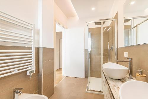 Un baño con lavabo, inodoro y ducha. en Stylish Poolside Apartment, Jesolo-Venice, en Lido di Jesolo