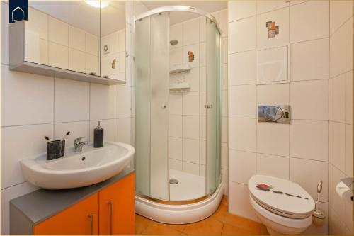 a bathroom with a shower and a toilet and a sink at Tema 13 in Ahlbeck