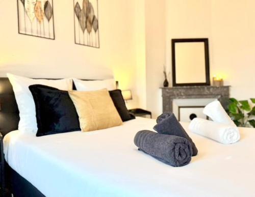 a bedroom with a white bed with pillows and a fireplace at Le Cocon Céleste - Appartement d'Exception - Vue sur les Alpes - Centre-Ville - Gare à 1 min in Valence