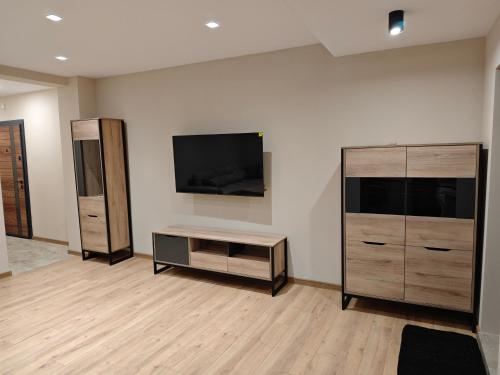 a living room with a flat screen tv on a wall at Ваканционен апартамент in Tryavna