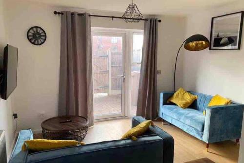a living room with a blue couch and a window at Central 4-Bed House - Parking Patio Garden Wifi in Lincoln