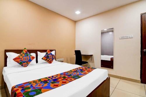 a bedroom with a large bed with a colorful blanket at FabHotel Gokul Residency in kolkata